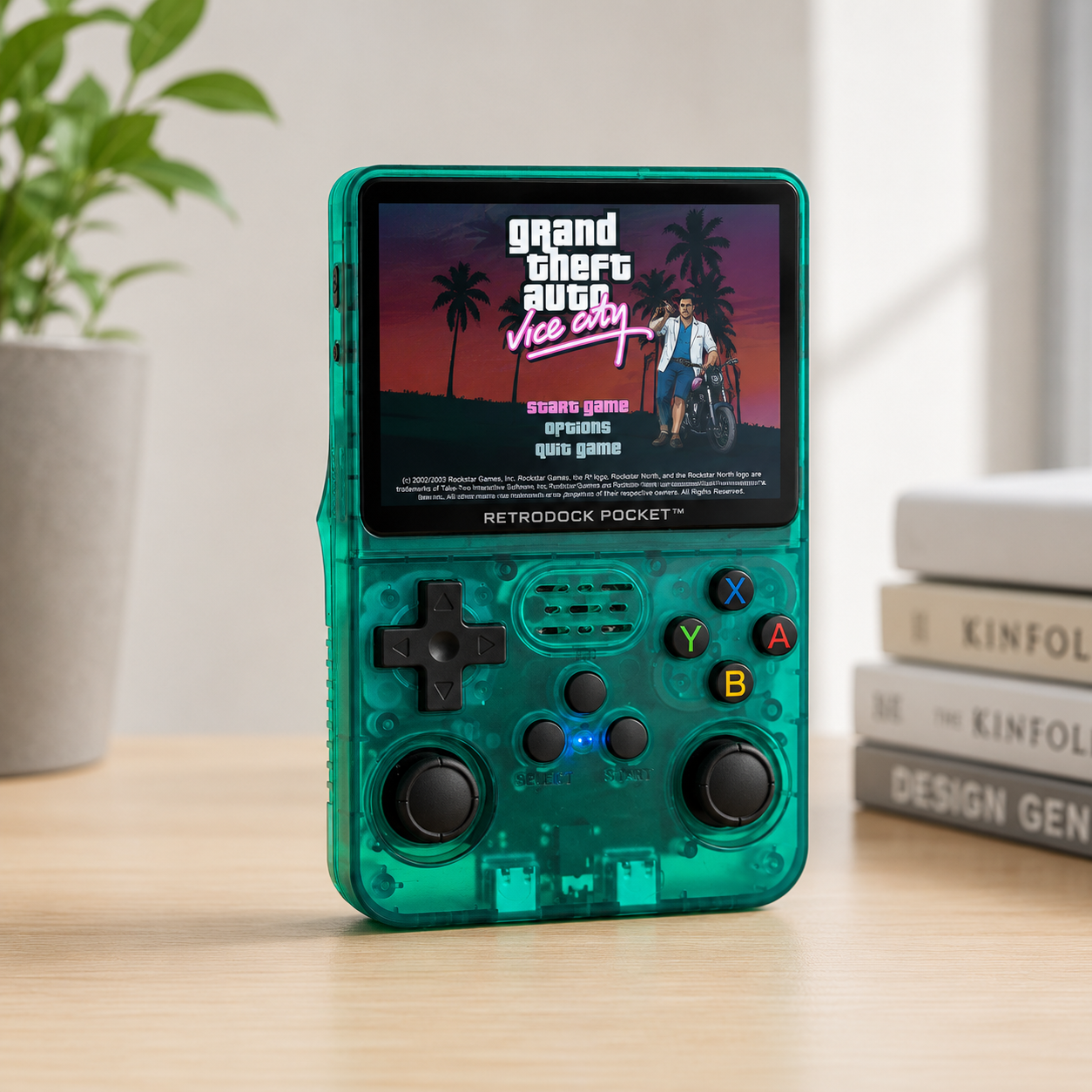 Handheld gaming console with 'Grand Theft Auto: Vice City' on screen, placed on a wooden surface.